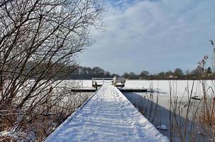 schöne Winteraufnahme an einem See und Wald mit Schnee und Eis. foto