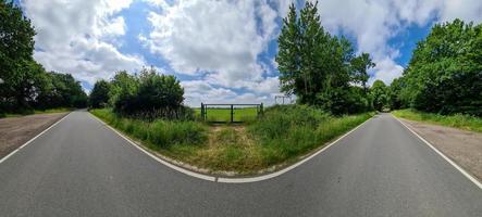 Schönes hochauflösendes Panorama einer nordeuropäischen Landstraße mit Feldern und grünem Gras. foto