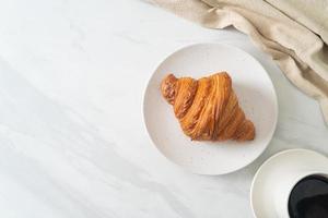 frisches Croissant auf weißer Platte foto