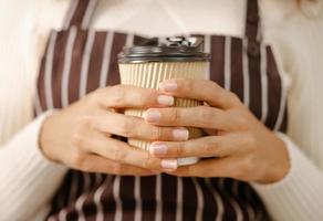 Nahaufnahmehand, die heiße Kaffeetasse hält foto