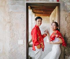 glückliches junges asiatisches paar in chinesischen traditionellen kleidern foto