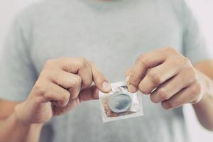Kondom gebrauchsfertig in männlicher Hand, Kondom sicher geben foto