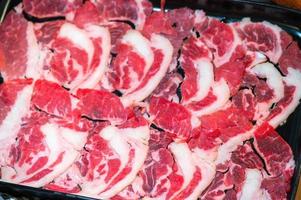 Schieben Sie rohes Rindfleisch für Yakiniku. dünnes stück rindfleisch für shabu hotpot japanischen essensstil. Frischfleisch-Chuck-Auge für Sukiyaki hautnah. Ansicht von oben foto