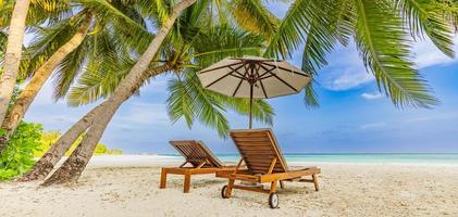 erstaunliches urlaubspanorama am strand der sommerinsel. zwei stühle mit palmblättern und regenschirm, nahe meer, horizont. exotische landschaft, tropisches paradies, paar-romantik-destination-banner. Seesand Himmel foto