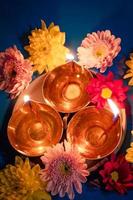 Frohes Diwali. Feiern des hinduistischen Lichterfestes. traditionelle Diya-Öllampen und Blumen auf blauem Hintergrund. foto