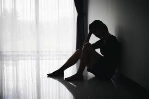 Die Silhouette einer gestressten und depressiven Frau, die unter Druck und Hoffnung arbeitet, trauriger Ausdruck, traurige Emotionen, Verzweiflung, Traurigkeit. foto