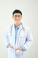 Ein hübscher Arzt mit Stethoskop, der selbstbewusst auf weißem Hintergrund steht foto