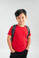 selbstbewusster kleiner Junge mit Rucksack foto