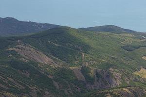 Berglandschaft, bewaldete Berge und blaues Meer, Draufsicht. foto