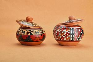 zwei bemalte handgefertigte Keramiktöpfe mit Deckel auf Kraftpapier