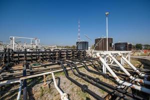 Industriegebiet, Stahlrohrleitungen, Ventile, Öltank, Kabel und Gehwege foto