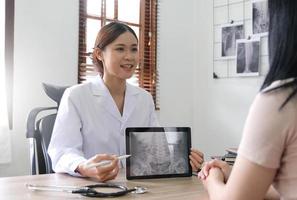 arzt und patient besprechen die röntgenergebnisse des brustkorbs auf einem digitalen tablet im büro der klinik