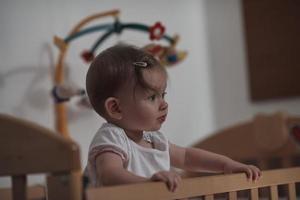 süßes kleines einjähriges baby und macht erste schritte im bett foto