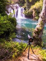 professionelle dslr-kamera auf einem stativ am schönen wasserfall foto