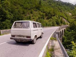 alter weißer Lieferwagen auf asphaltierter Straße in wunderschöner Landschaft foto