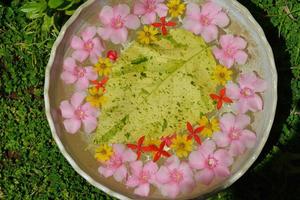 Wasserschale mit schönem Blumenhintergrund foto