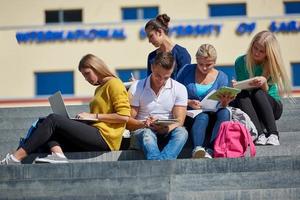 Studenten sitzen draußen auf Stufen foto