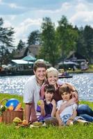 glückliche familie, die zusammen in einem picknick im freien spielt foto