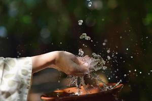 frisches Wasser auf die Hände der Frau spritzen foto