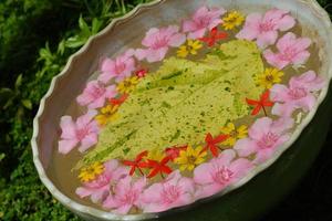 Wasserschale mit schönem Blumenhintergrund foto