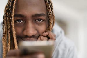 afro guy benutzt während einer pandemie ein handy und durchsucht soziale medien foto