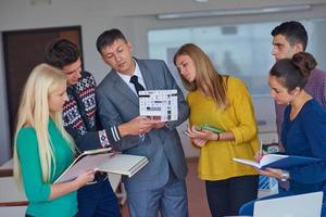 gruppe von schülern, die mit dem lehrer am hausmodell arbeiten foto