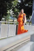 glückliche schwangere Frau, die per Handy spricht foto