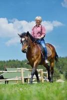 glückliche Frau auf dem Pferd foto