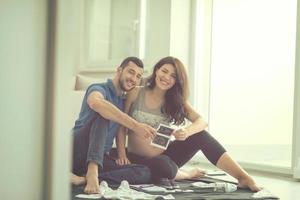schwangeres paar, das eine liste von dingen für ihr ungeborenes baby überprüft foto