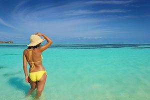 schöne Frau, die sich am tropischen Strand ausruht foto