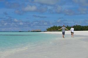 glückliches junges Paar in den Sommerferien hat Spaß und entspannt sich am Strand foto