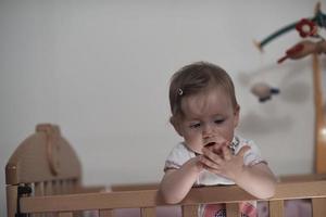 süßes kleines einjähriges baby und macht erste schritte im bett foto