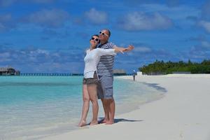 glückliches junges Paar in den Sommerferien hat Spaß und entspannt sich am Strand foto