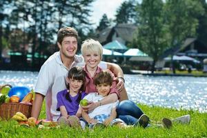 glückliche familie, die zusammen in einem picknick im freien spielt foto