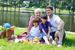 glückliche familie, die zusammen in einem picknick im freien spielt foto