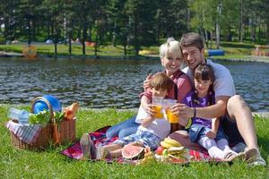 glückliche familie, die zusammen in einem picknick im freien spielt foto