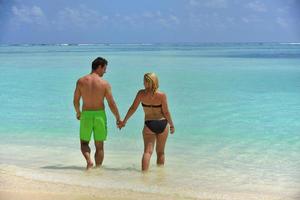 glückliches junges Paar in den Sommerferien hat Spaß und entspannt sich am Strand foto