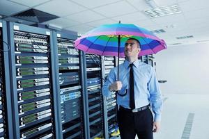 Geschäftsmann hält Regenschirm im Serverraum foto