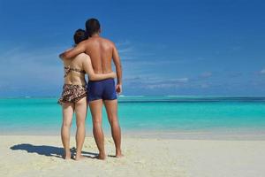glückliches junges Paar, das den Sommer am Strand genießt foto