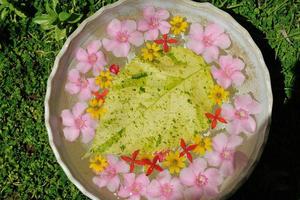 Wasserschale mit schönem Blumenhintergrund foto