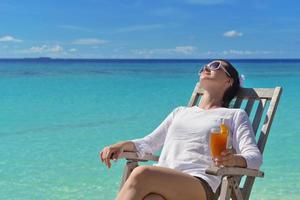 schöne junge frau mit einem getränk am meer foto