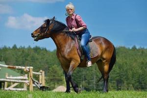 glückliche Frau auf dem Pferd foto