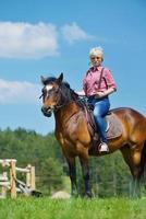 glückliche Frau reitet Pferd foto