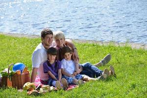 glückliche familie, die zusammen in einem picknick im freien spielt foto