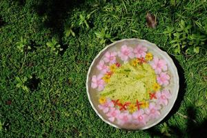 Wasserschale mit schönem Blumenhintergrund foto