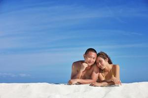 glückliches junges Paar, das den Sommer am Strand genießt foto