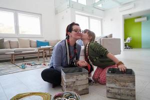 mutter und kleine mädchentochter spielen zu hause mit schmuck foto