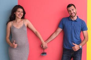 junges glückliches paar, das neugeborene babyschuhe hält foto