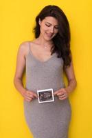 schwangere frau, die ultraschallbild zeigt foto
