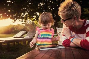 Mutter und ihre kleine Tochter mit Tablet-Computer foto